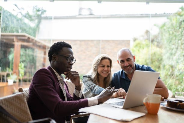 Couple With Laptop Talking With Advisor At Home