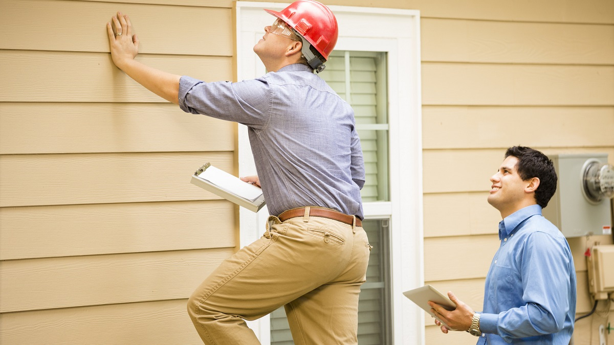 Two appraisers looking at the outside of a house.