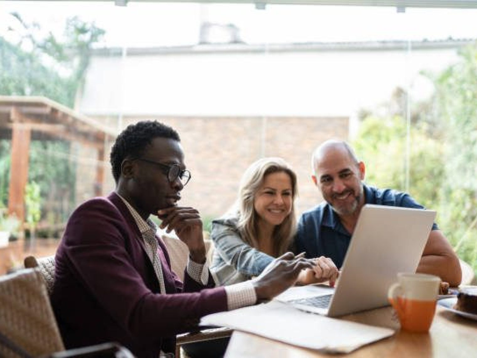 Couple With Laptop Talking With Advisor At Home