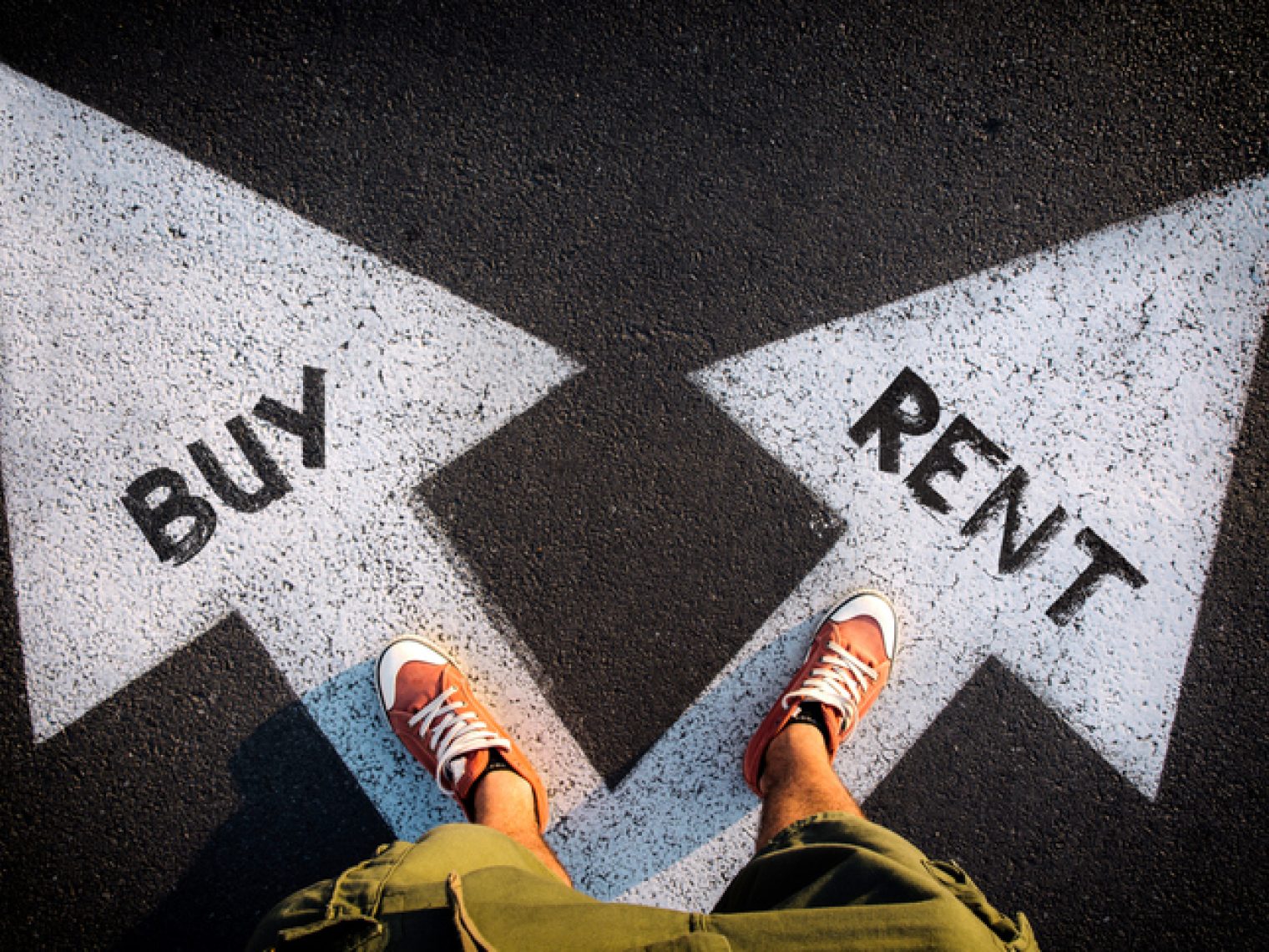 A person standing on a pavement with two diverging arrows pointing in opposite directions, one labeled "BUY" and the other "RENT."