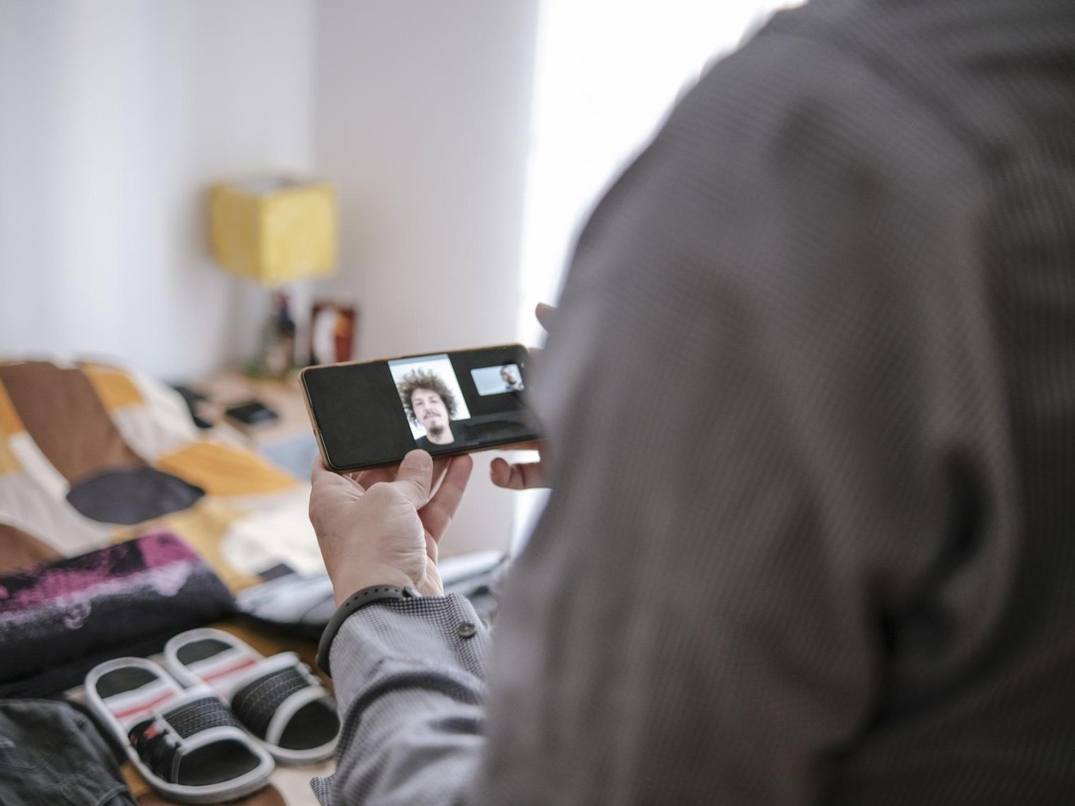 Overseas servicemember video chatting with loan officer. A packed, open suitcase can be seen in the background