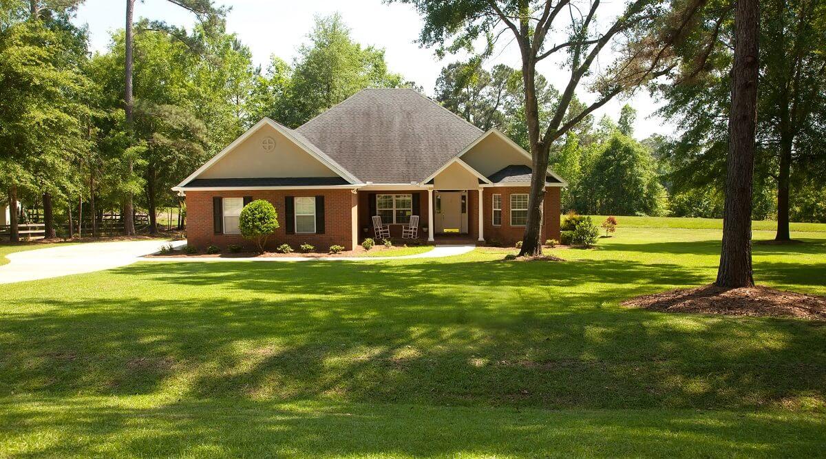 Exterior of a brick home with a large yard.