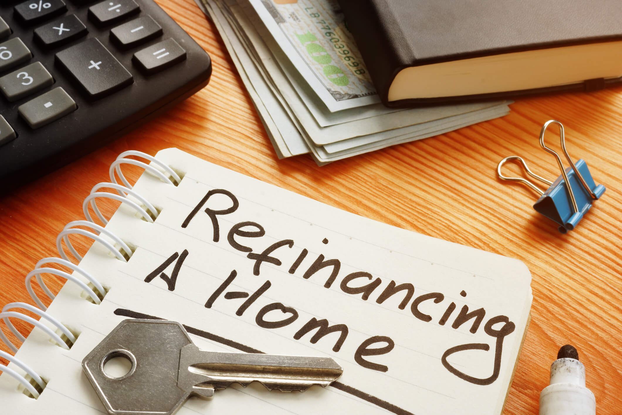 Notebook on a desk that says "Refinancing a home."