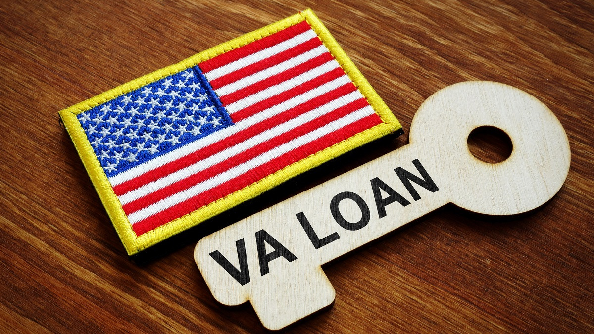 Close up of American flag patch next to a wood-carved key that says "VA Loan".